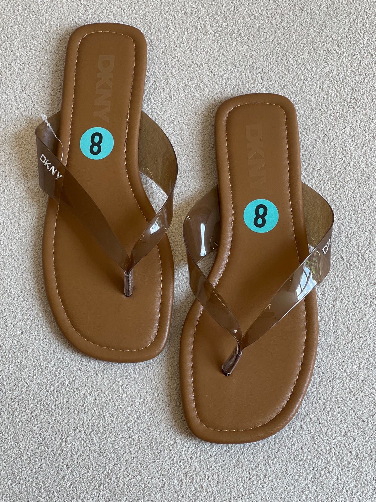 DKNY flip-flops featuring tan footbeds and clear straps