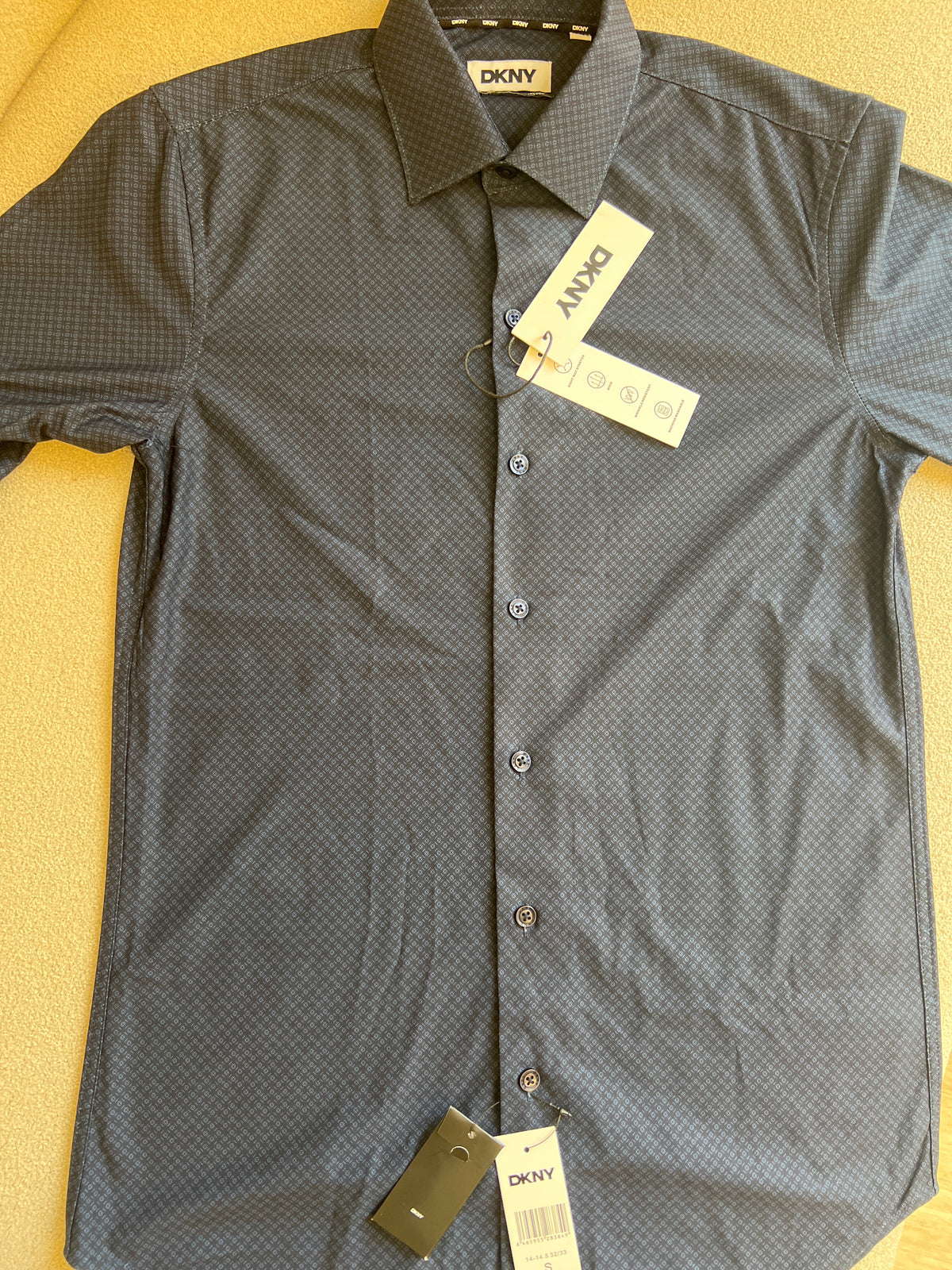 DKNY men's dress shirt is featured in a deep navy blue with a subtle textured pattern