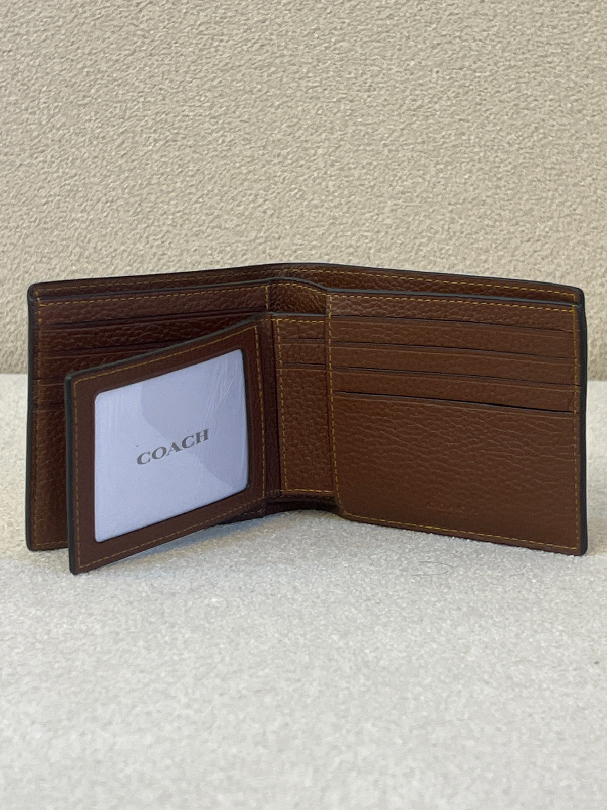 Coach 3-in-1 wallet is crafted from signature crossgrain leather with a brown embossed design