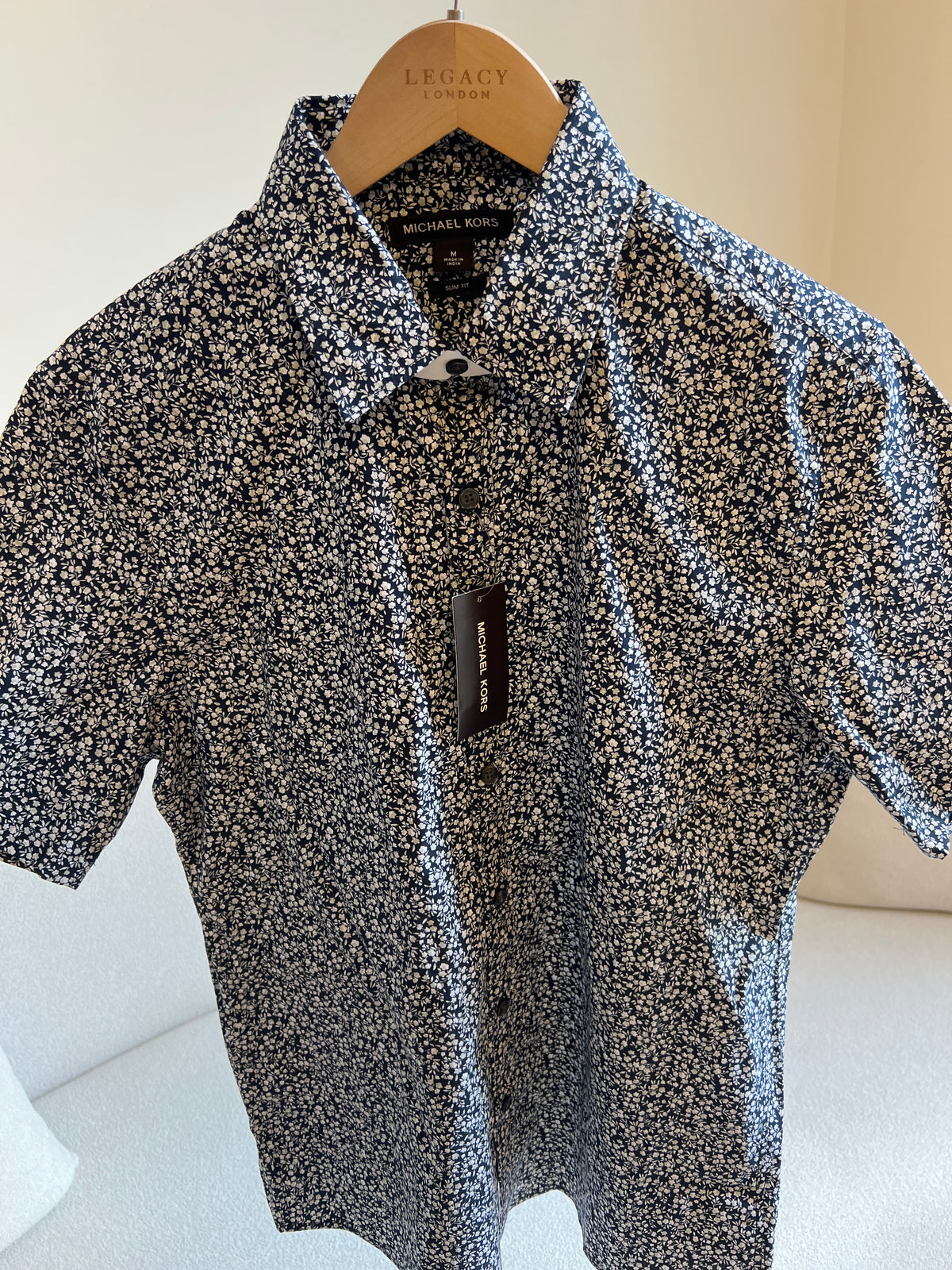 Michael Kors men's black and white floral print short-sleeve shirt features a slim fit and stretch fabric for comfort