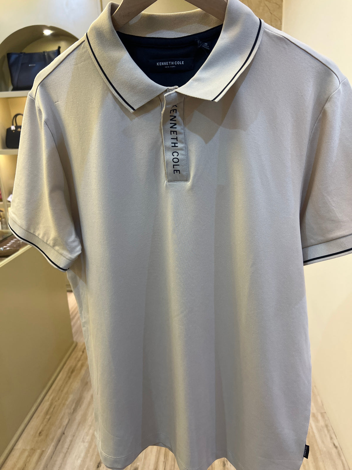 Kenneth Cole branded men's white polo shirt features a distinctive branded zip-placket and contrast tipping on the collar