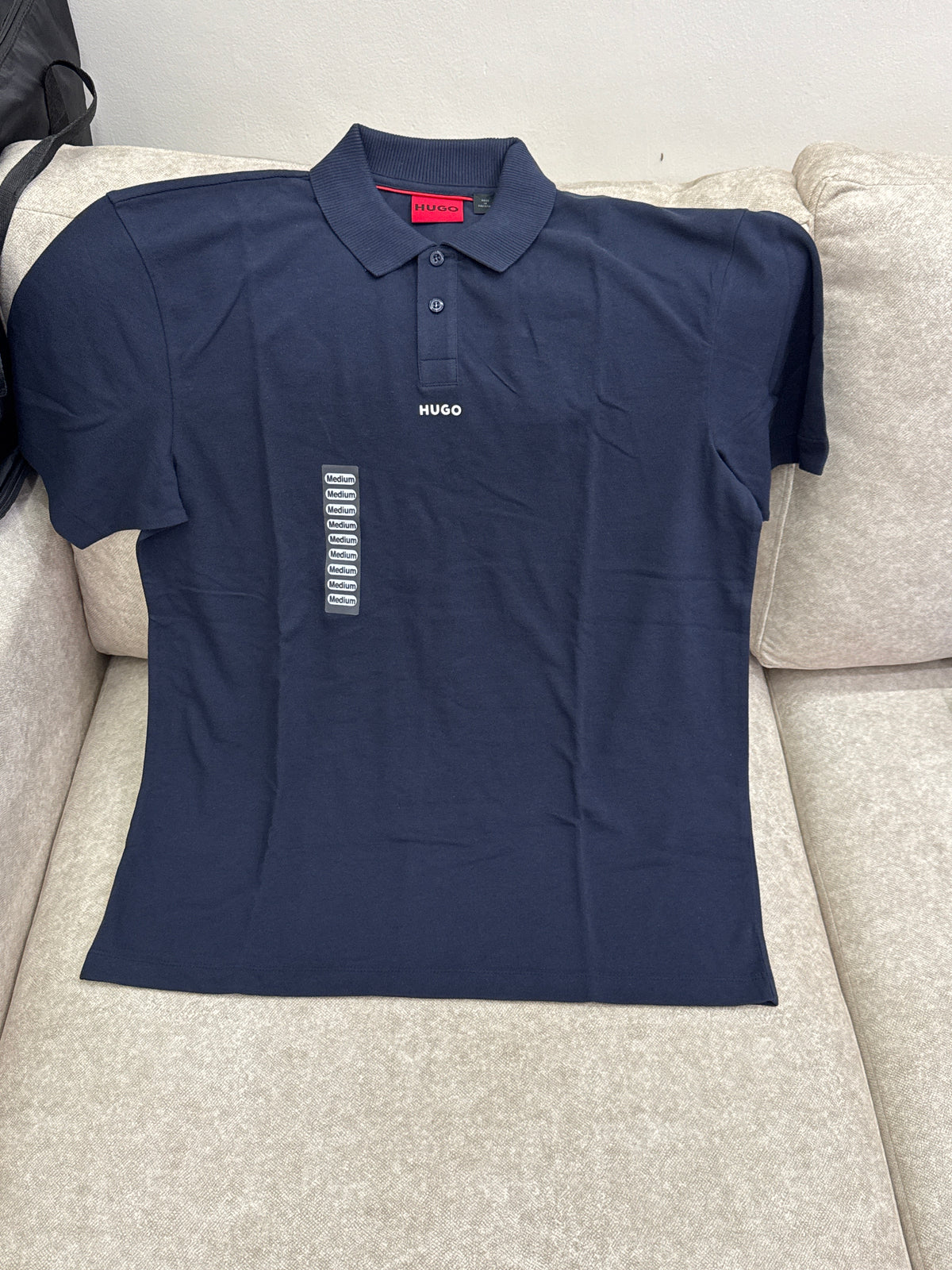 This is a dark blue cotton polo shirt by HUGO featuring a chest logo print