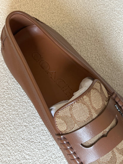 Coach men's loafers are the Liam Driver model, featuring a distinctive signature jacquard canvas panel contrasted with solid leather