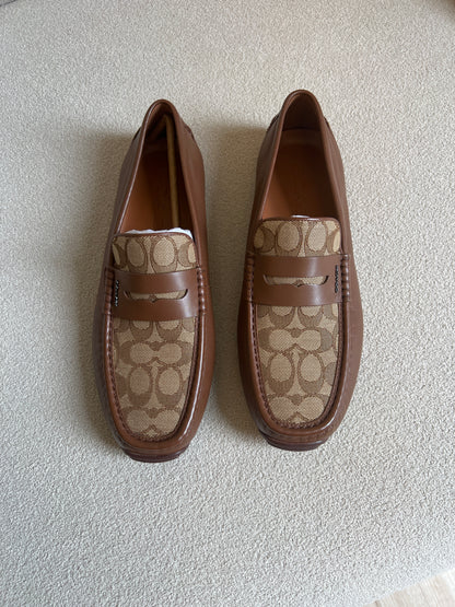 Coach men's loafers are the Liam Driver model, featuring a distinctive signature jacquard canvas panel contrasted with solid leather