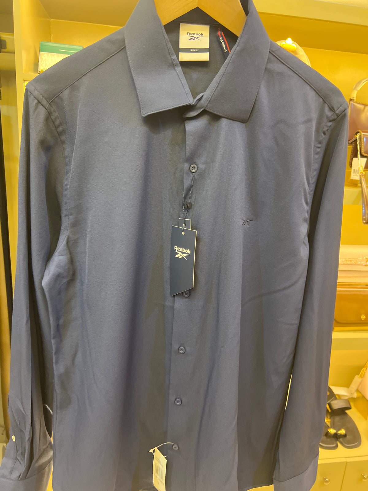 Reebok brand shirt is a navy blue long-sleeved garment featuring a slim fit and a classic collar