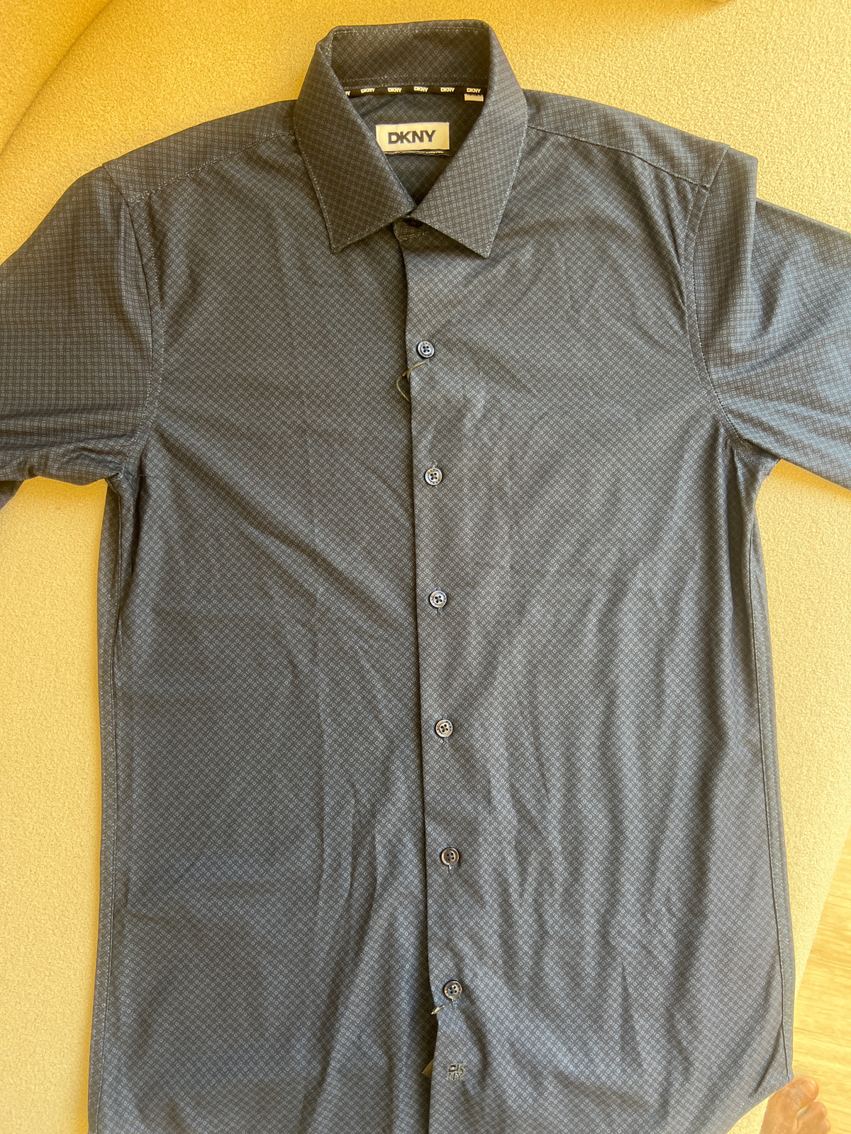 DKNY men's dress shirt is featured in a deep navy blue with a subtle textured pattern