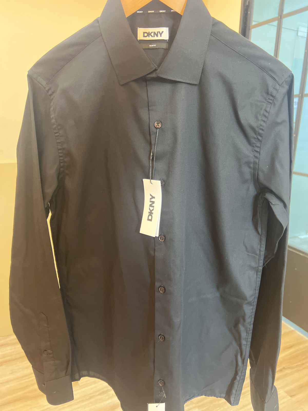 DKNY men's black dress shirt featuring a classic collar, front button fastening, and long sleeves