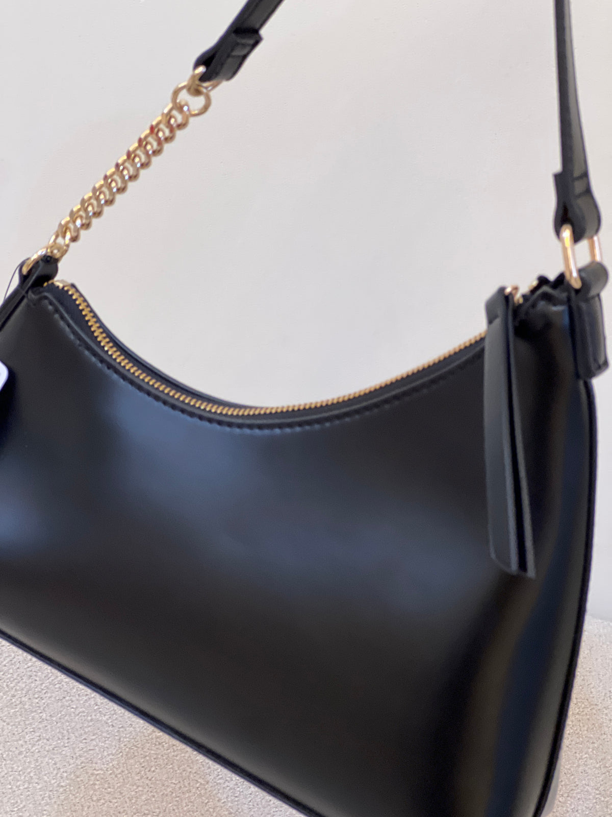 Black GUESS Noelle Top Zip Shoulder Bag, featured with gold-tone hardware and a combination chain and faux-leather shoulder strap