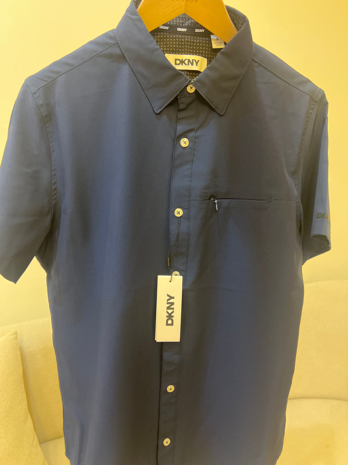 DKNY Men's Casual Button Down Short Sleeve Shirt, featuring a modern fit, stretch fabric, and a zipped chest pocket