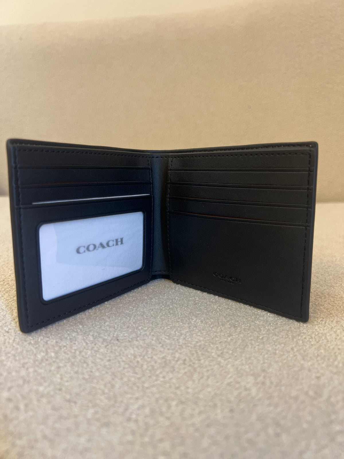 Coach ID Billfold Wallet in Signature Canvas, often found in Tan/Black or Mahogany