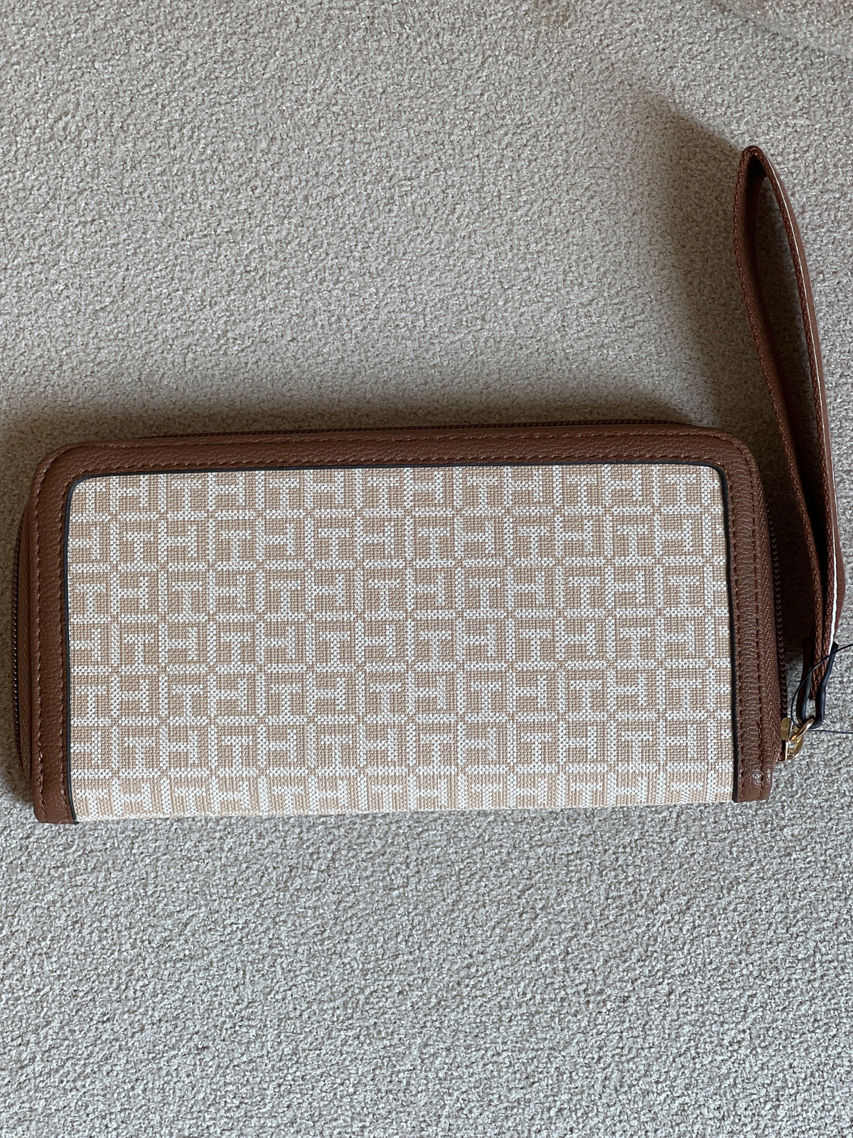 Tommy Hilfiger monogram jacquard zip-around wallet features a classic beige pattern with brown trim