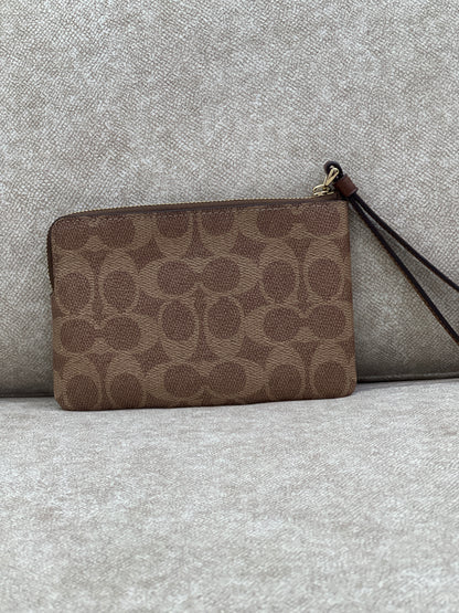 Coach Corner Zip Wristlet in signature canvas with a brown leather stripe